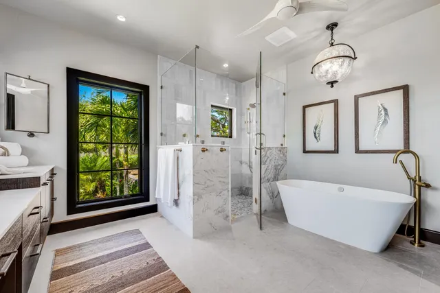 a spacious bathroom with a balcony a bathtub and a shower