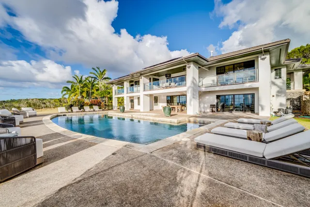 a view of a house with swimming pool and sitting area