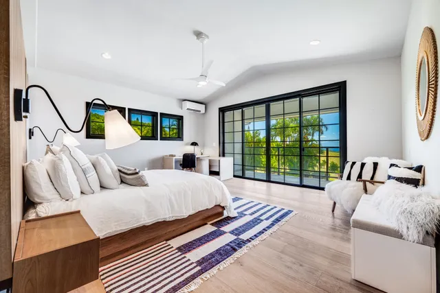 a spacious bedroom with a bed couch and a large window