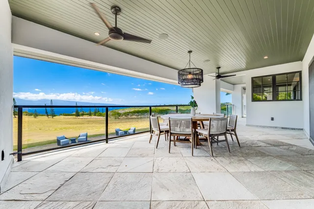 a view of a patio with a table and chairs under an umbrella