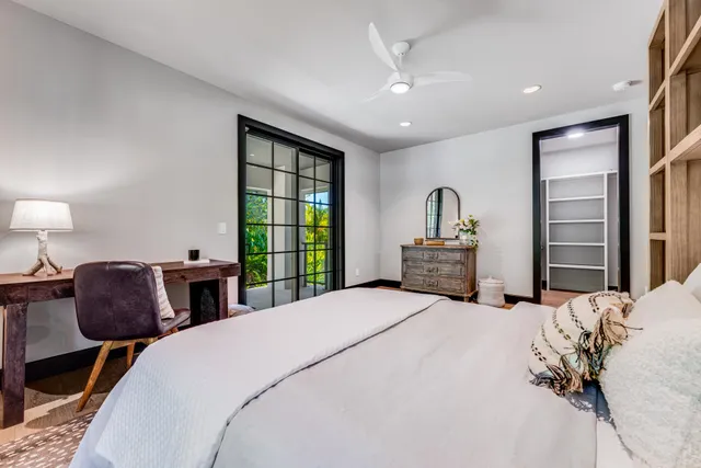 a bedroom with a bed and a large window