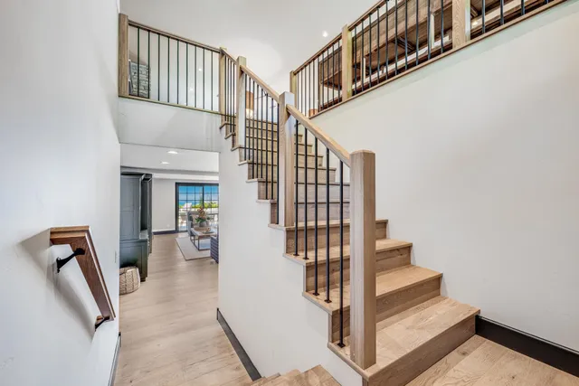 a view of staircase with lots of frames on wall and a potted plant