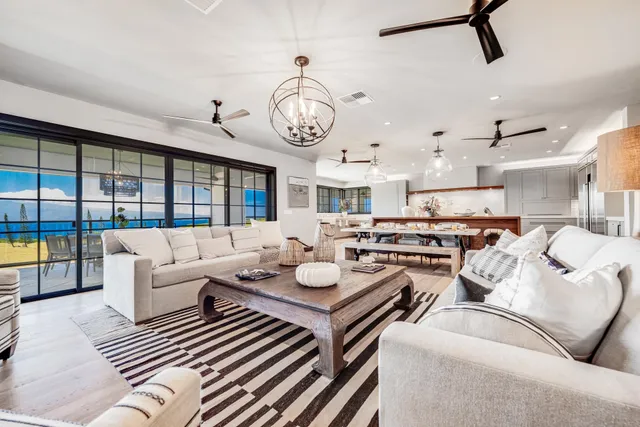 a living room with furniture kitchen view and a large window