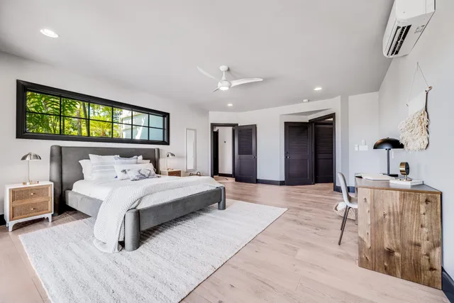 a spacious bedroom with a large bed and a chandelier