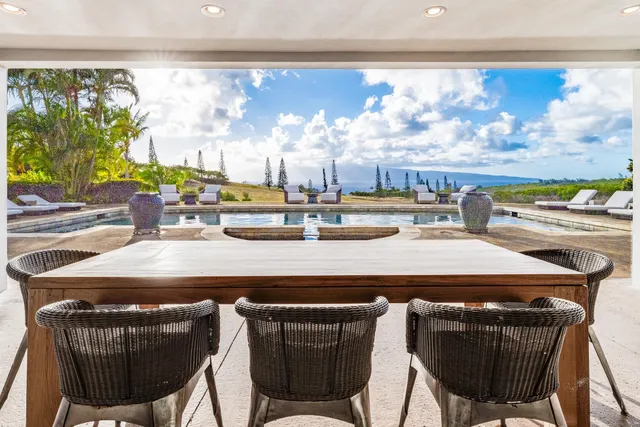 a view of a dining room with furniture a large window and garden view