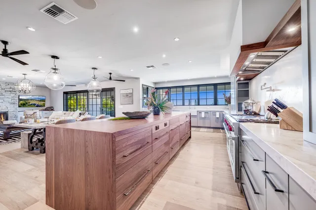 a large kitchen with stainless steel appliances kitchen island a large counter top a stove and a sink