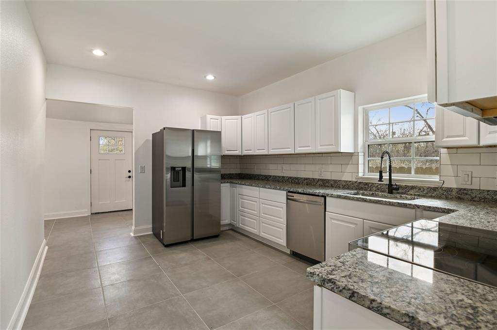1106 West Chestnut Street Denison, TX 75020 - Photo 11 of 38 Kitchen featuring white cabinets, stainless steel appliances, tasteful backsplash, and sink