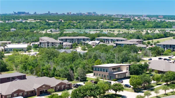 an aerial view of residential houses with outdoor space and trees