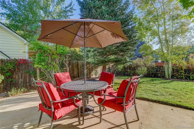 a patio with a table and chairs under an umbrella