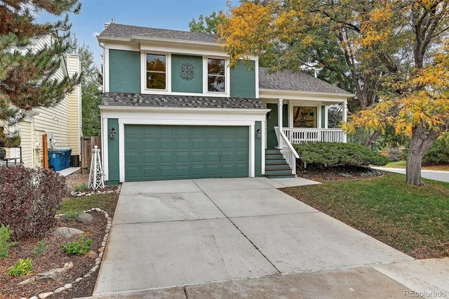 a view of a house with a yard and large tree