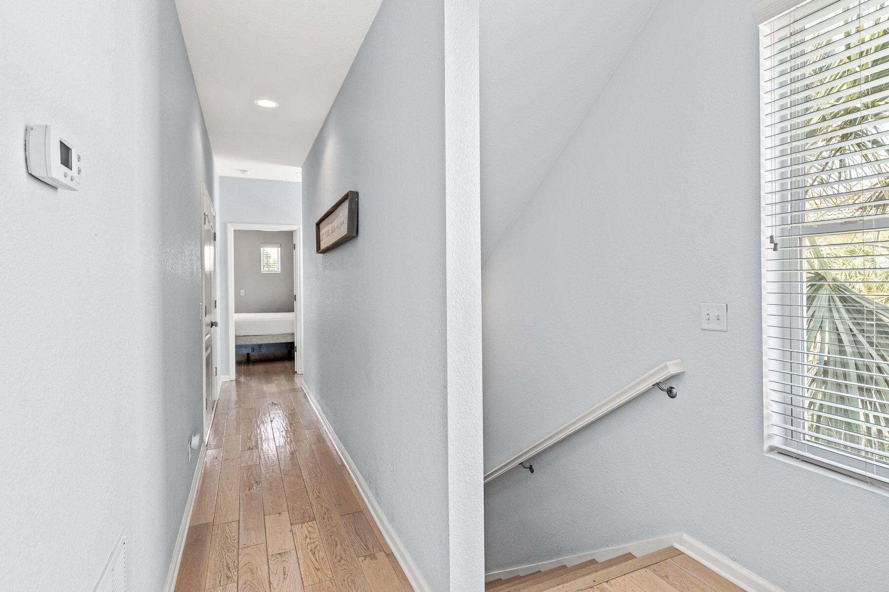 156 Southfields Road Panama City Beach, FL 32413 - Photo 15 of 35 a view of a hallway with wooden floor and a bathroom