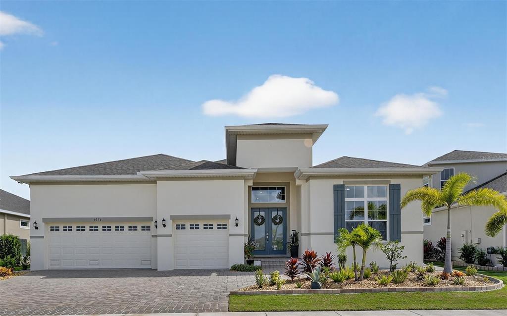 a front view of a house with a garden and plants