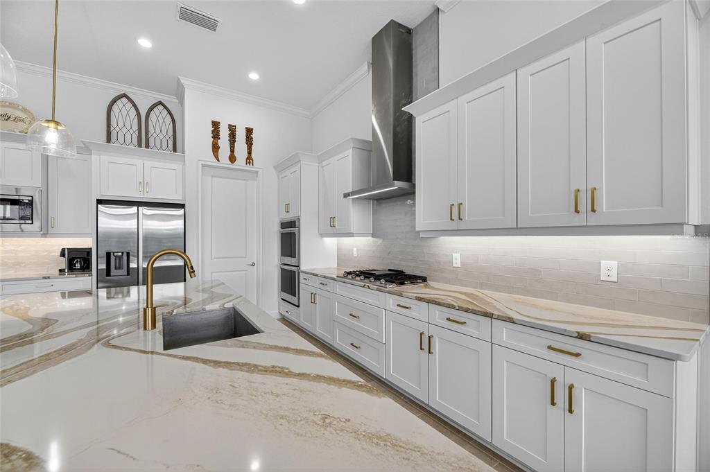 5975 Blakeney Loop Apollo Beach, FL 33572 - Photo 18 of 100 a kitchen with stainless steel appliances granite countertop a sink a stove and a refrigerator