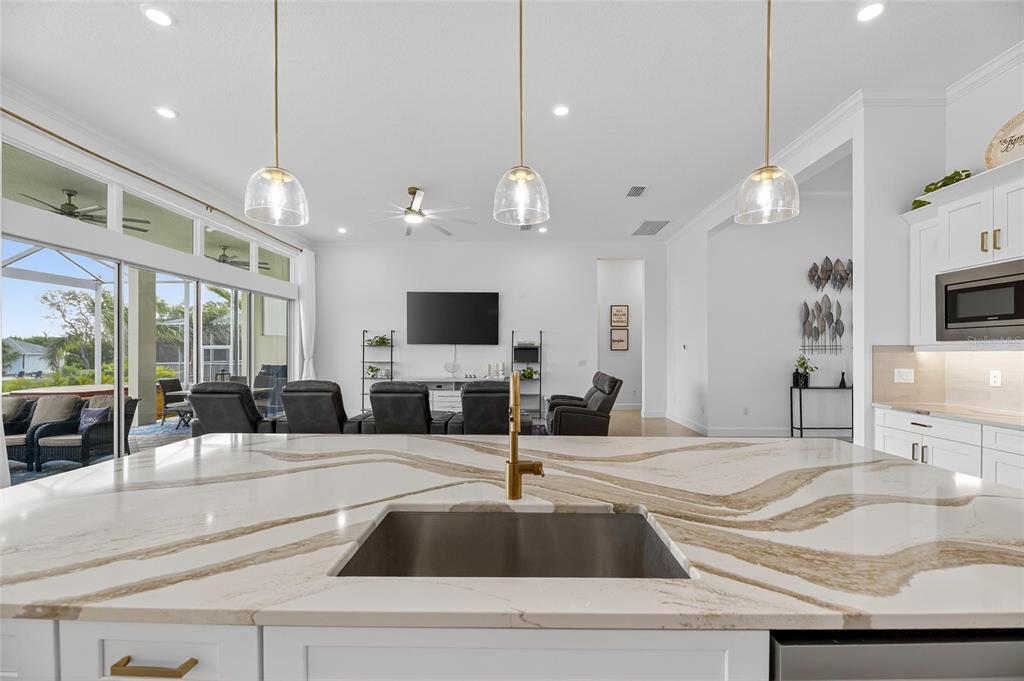 5975 Blakeney Loop Apollo Beach, FL 33572 - Photo 18 of 100 a kitchen with kitchen island a sink and a large window