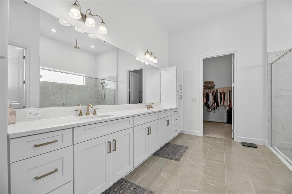 5975 Blakeney Loop Apollo Beach, FL 33572 - Photo 27 of 100 a spacious bathroom with a double vanity sink shower and a mirror