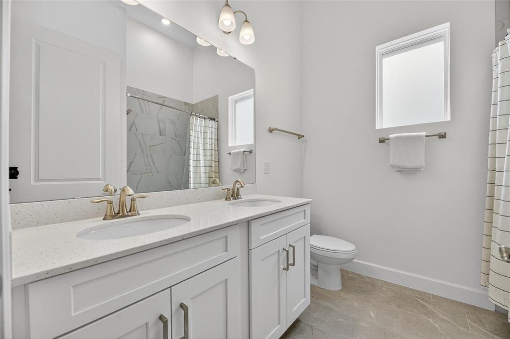 5975 Blakeney Loop Apollo Beach, FL 33572 - Photo 30 of 100 a bathroom with a sink a toilet and a mirror