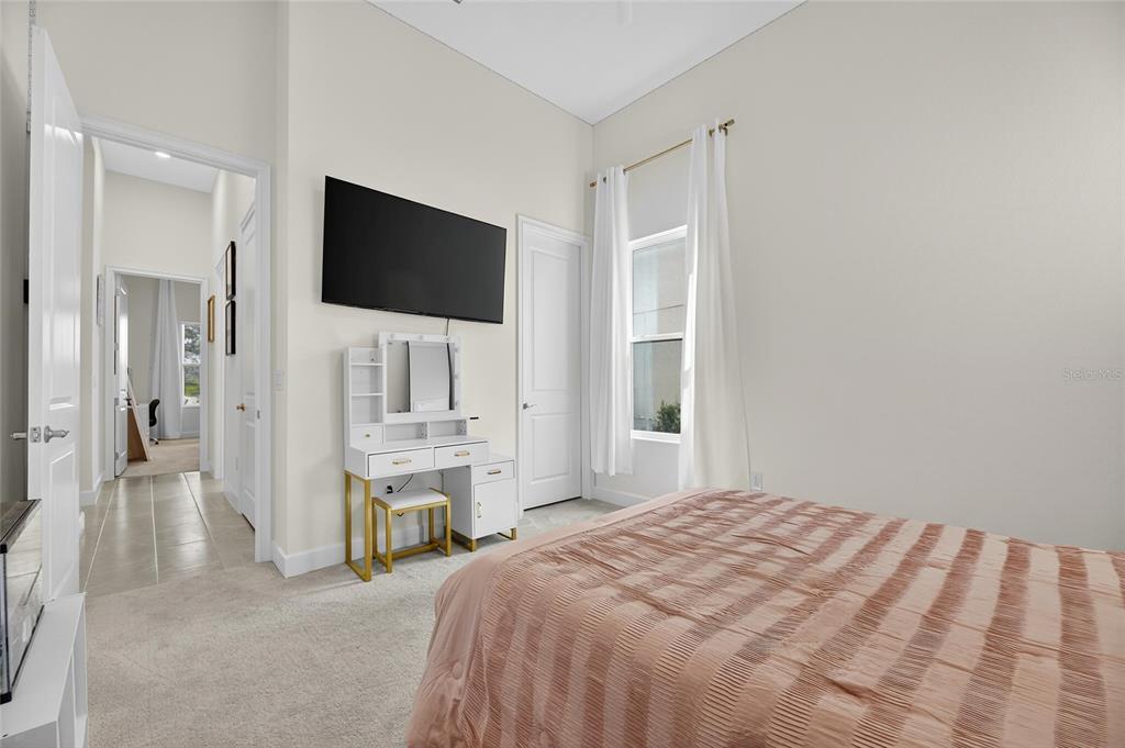 5975 Blakeney Loop Apollo Beach, FL 33572 - Photo 36 of 100 a bedroom with a bed and a flat screen tv