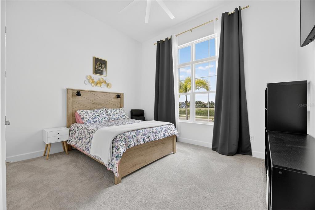 5975 Blakeney Loop Apollo Beach, FL 33572 - Photo 42 of 100 a bedroom with a bed and a flat tv screen on the dresser