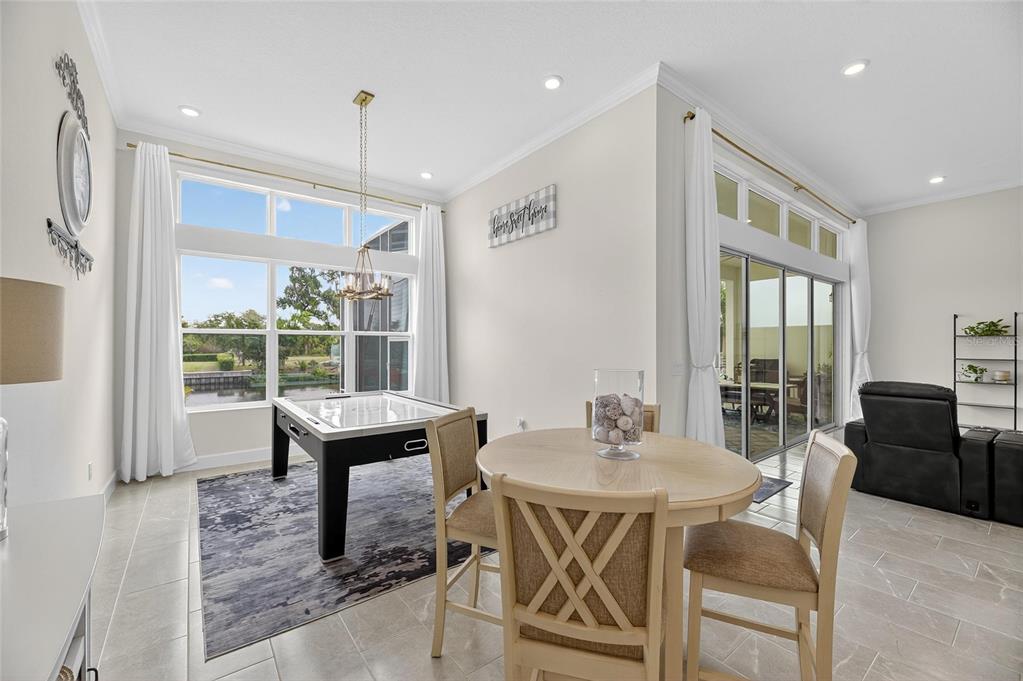 5975 Blakeney Loop Apollo Beach, FL 33572 - Photo 49 of 100 a dining room with furniture a chandelier and wooden floor