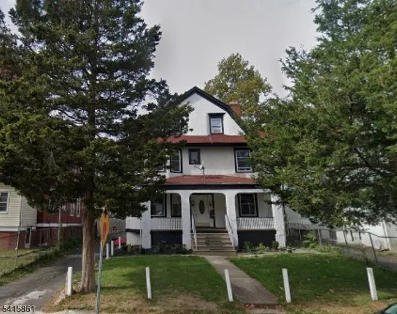 a house that has a tree in front of a house