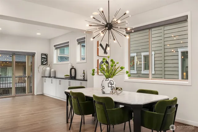 a dining room with furniture potted plants and wooden floor