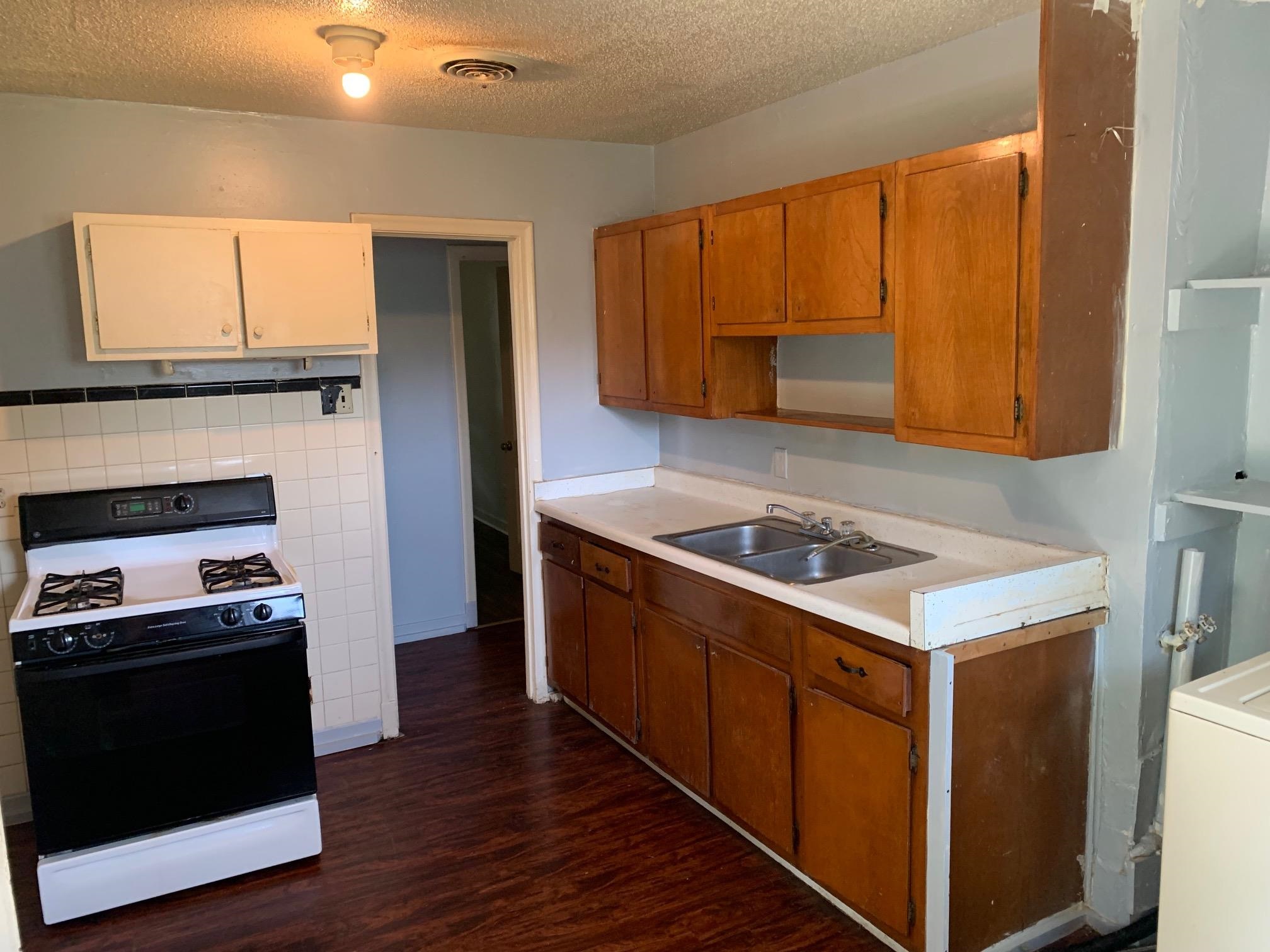 1610 Ozan Street Memphis, TN 38108 - Photo 9 of 9 a kitchen with a stove and a refrigerator