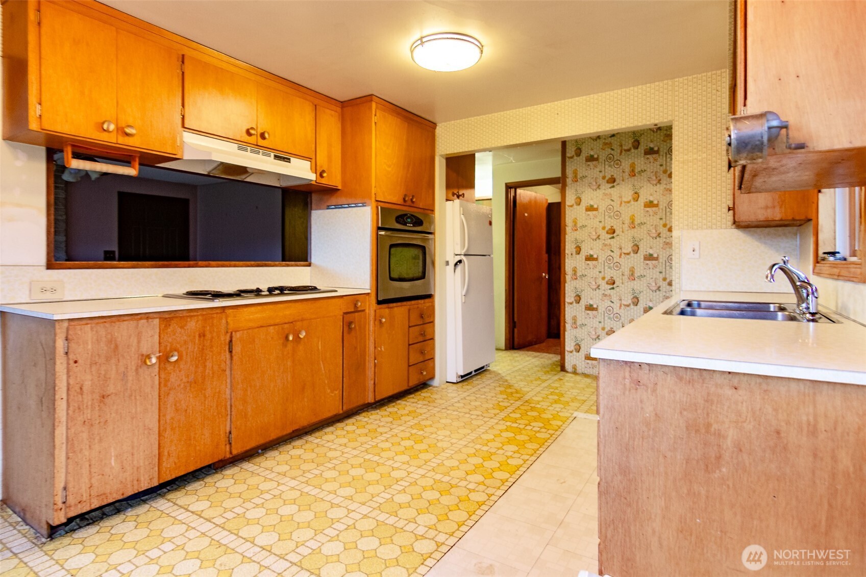 22731 Hull Road Mount Vernon, WA 98274 - Photo 7 of 26 a view of a kitchen with kitchen island a sink wooden floor and a refrigerator