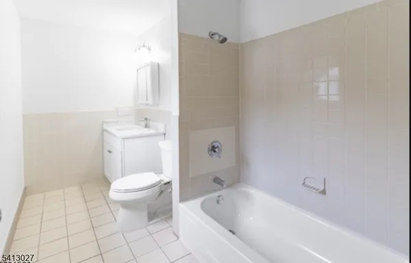 a bathroom with a toilet a sink a mirror and bathtub