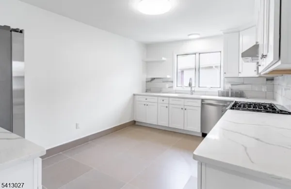 a kitchen with stainless steel appliances a sink a stove a refrigerator and cabinets