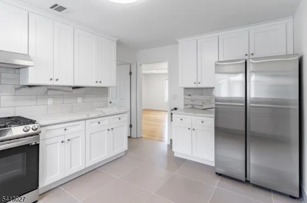 a kitchen with white cabinets stainless steel appliances and a sink