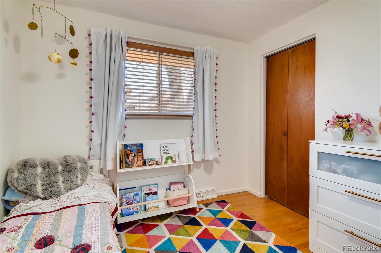 1377 South Oneida Street Denver, CO 80224 - Photo 13 of 27 a bedroom with a bed and a dresser in it