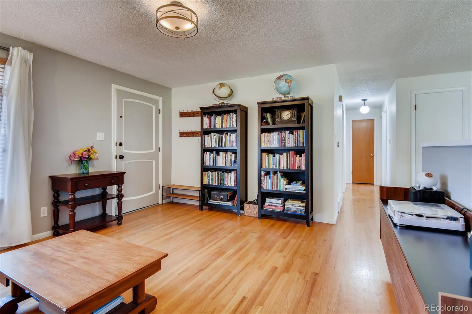 1377 South Oneida Street Denver, CO 80224 - Photo 5 of 27 a living room with furniture a table and bookshelf