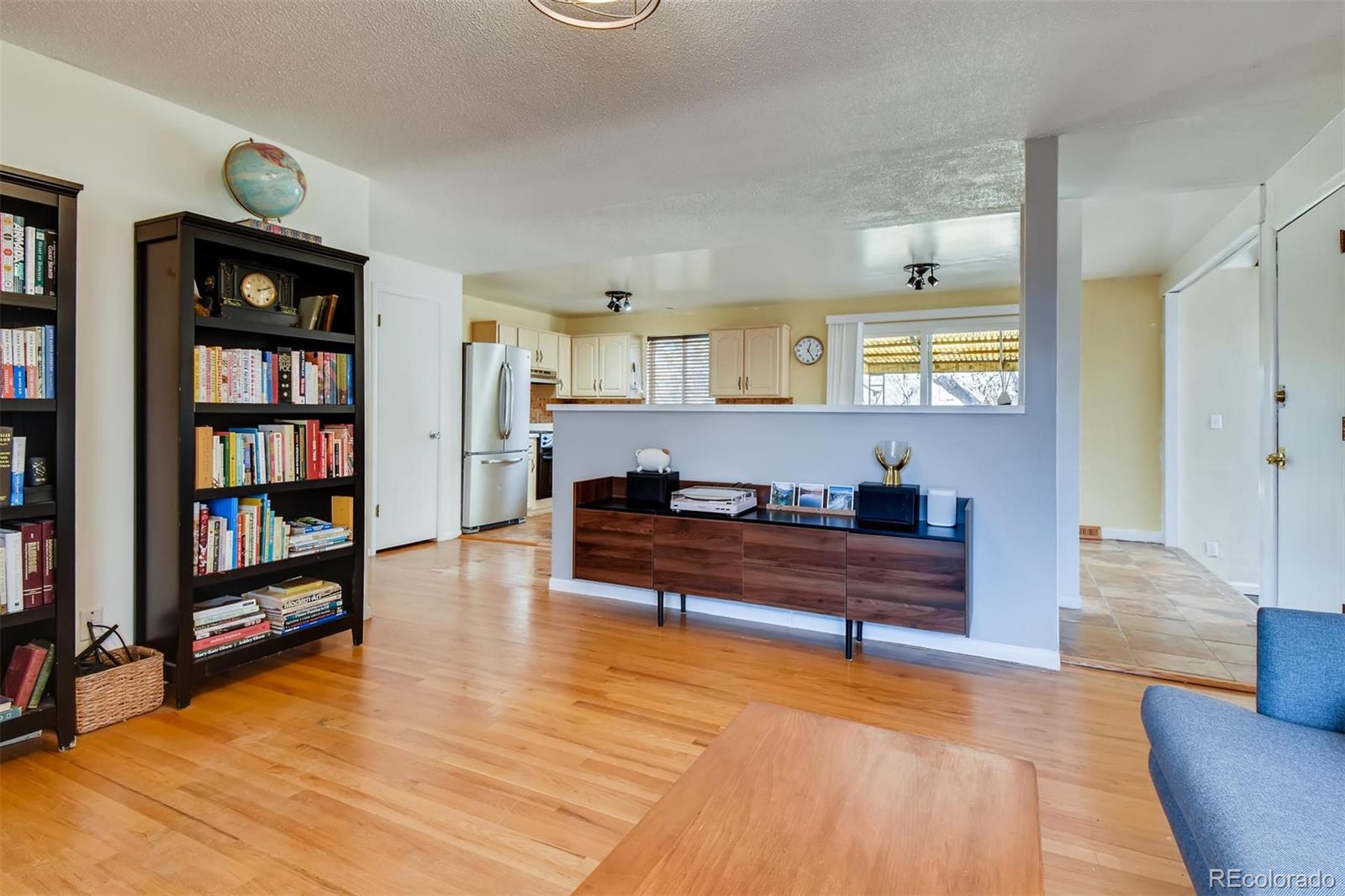 1377 South Oneida Street Denver, CO 80224 - Photo 6 of 27 a living room with furniture and a book shelf