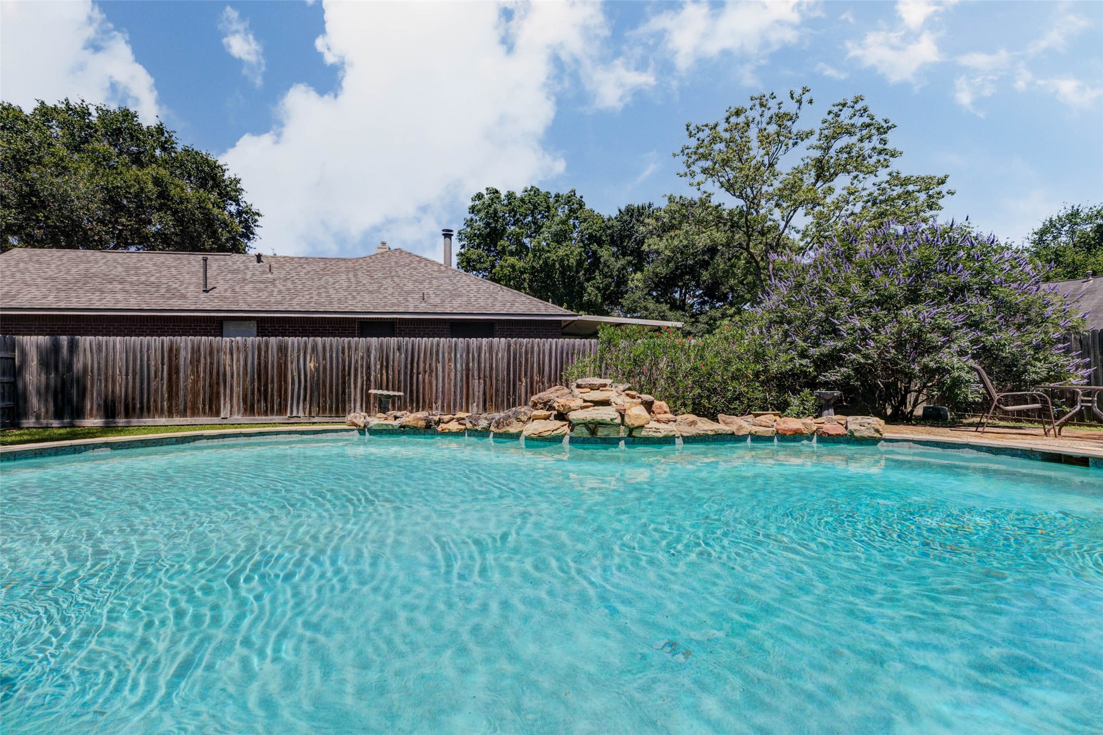 9215 Landry Boulevard Spring, TX 77379 - Photo 35 of 42 The backyard oasis features a massive sparkling pool situated on the additional lot, complete with a beautiful rock waterfall feature and mature landscaping.