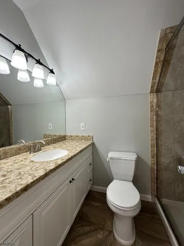 a bathroom with a granite countertop toilet and a sink