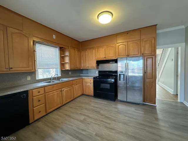 a kitchen with granite countertop a refrigerator stove top oven and sink