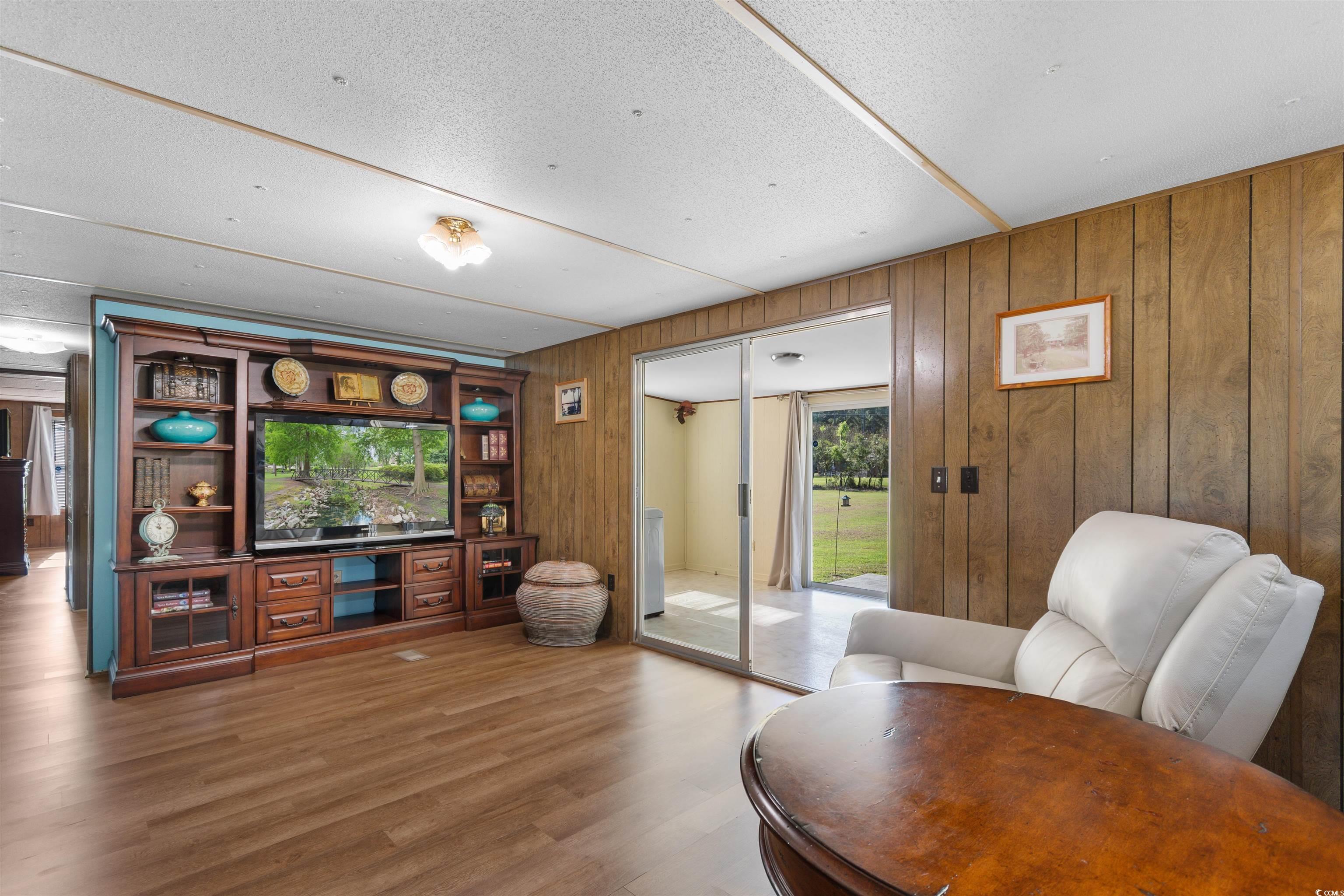 299 Williams Hill Road Hemingway, SC 29554 - Photo 14 of 40 Living area featuring wood finished floors, wooden walls, and a textured ceiling