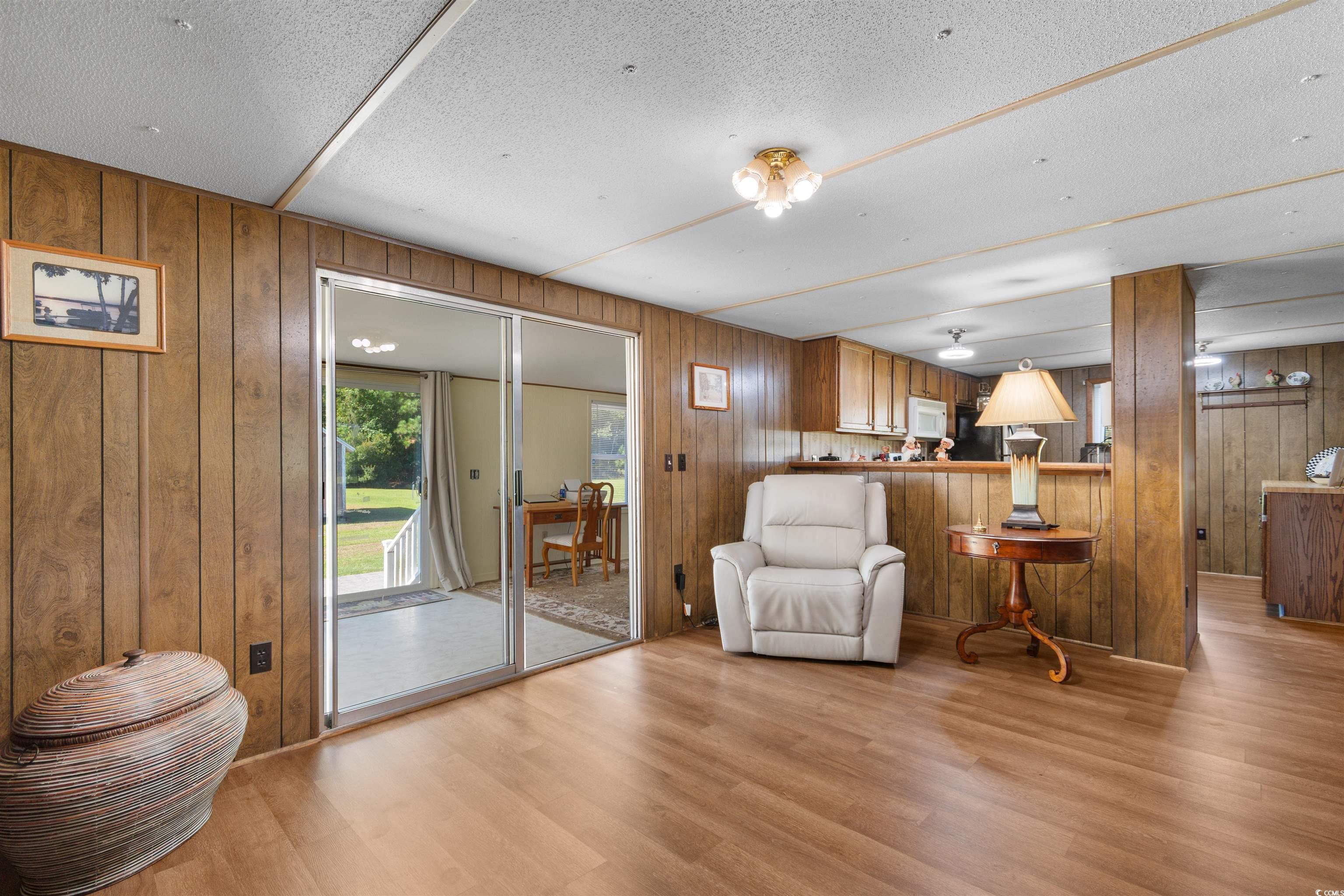 299 Williams Hill Road Hemingway, SC 29554 - Photo 15 of 40 Living area with light wood-style flooring, a textured ceiling, and wood walls
