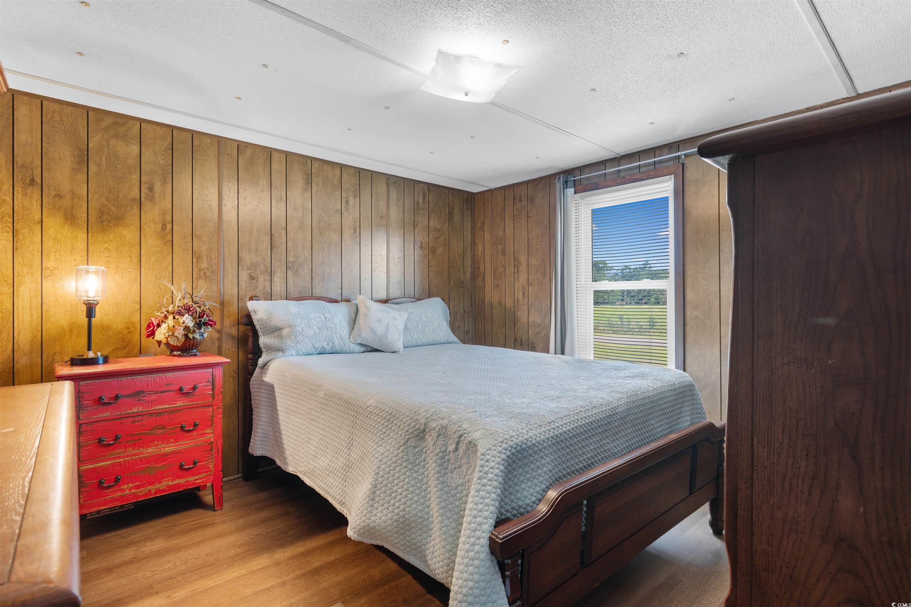 299 Williams Hill Road Hemingway, SC 29554 - Photo 18 of 40 Bedroom with wooden walls, wood finished floors, and a textured ceiling
