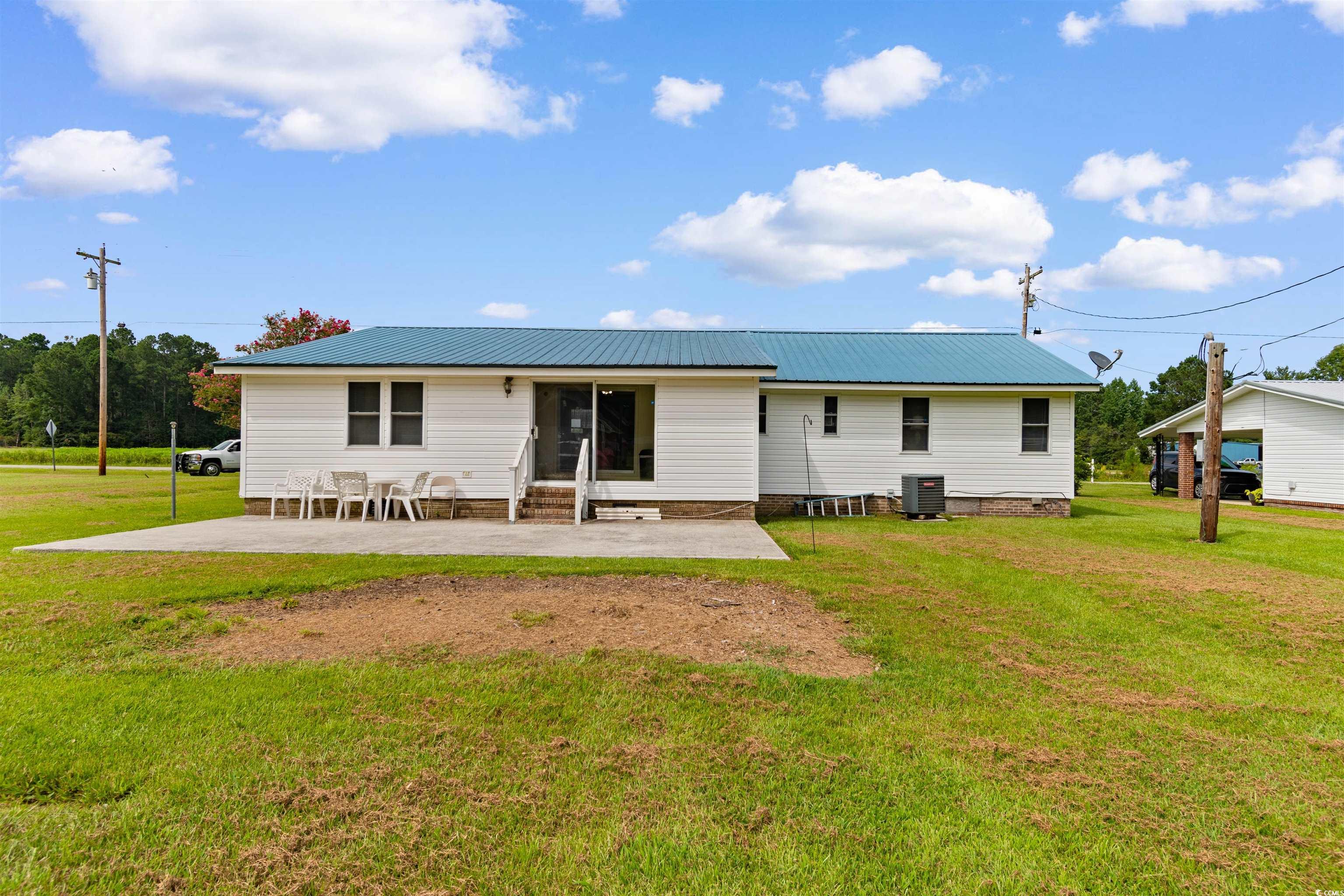 299 Williams Hill Road Hemingway, SC 29554 - Photo 2 of 40 Back of property with a lawn, a patio area, and a metal roof