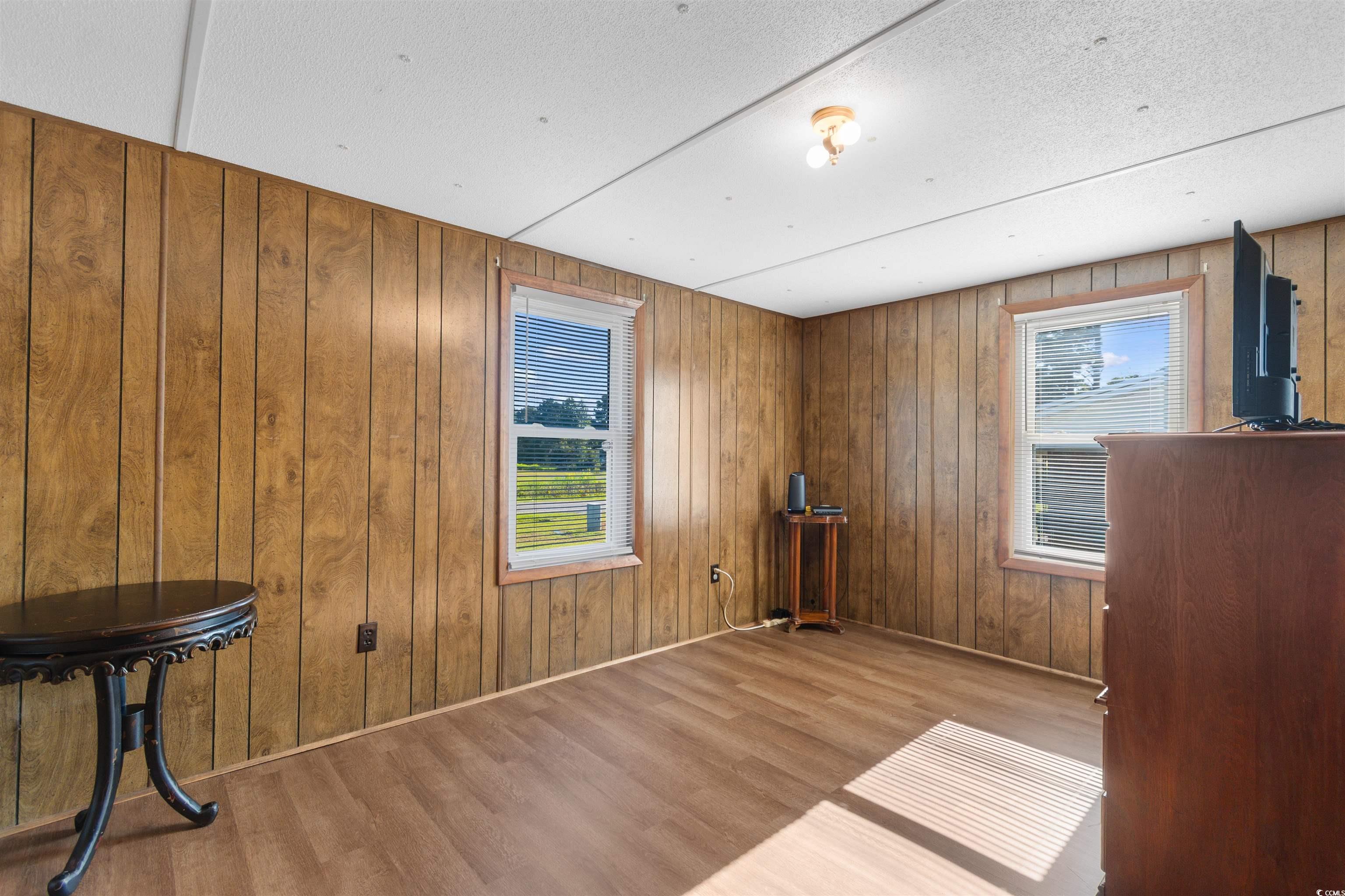 299 Williams Hill Road Hemingway, SC 29554 - Photo 21 of 40 Unfurnished room featuring wood finished floors, plenty of natural light, a textured ceiling, and wood walls