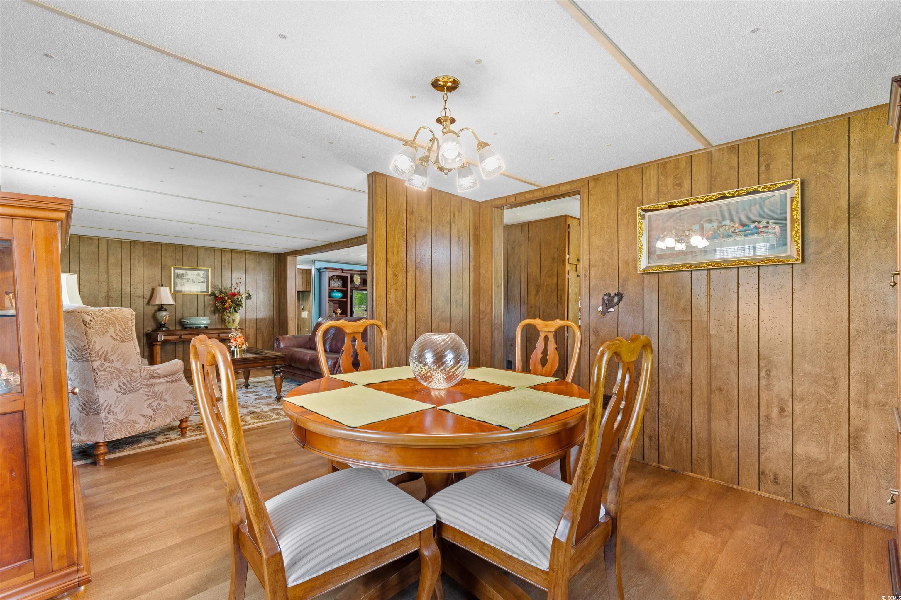 299 Williams Hill Road Hemingway, SC 29554 - Photo 7 of 40 Dining area featuring wood finished floors, a chandelier, and wood walls
