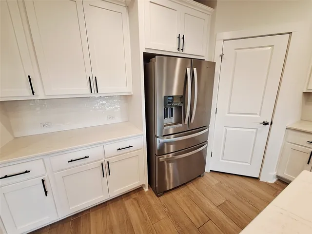 a kitchen with stainless steel appliances white cabinets and wooden floors