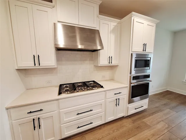 a kitchen with stainless steel appliances white cabinets and a stove
