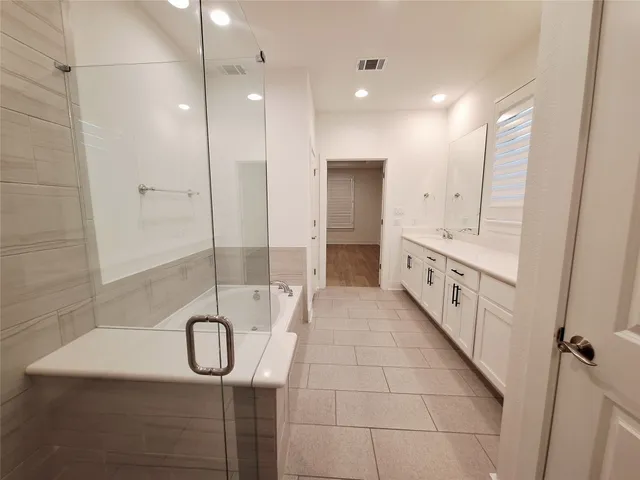 a bathroom with a double vanity sink a toilet and shower