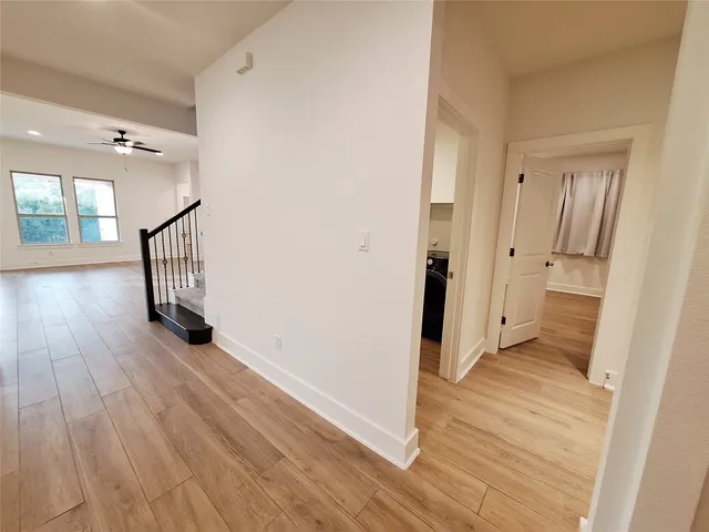 a view of a hallway with wooden floor and staircase