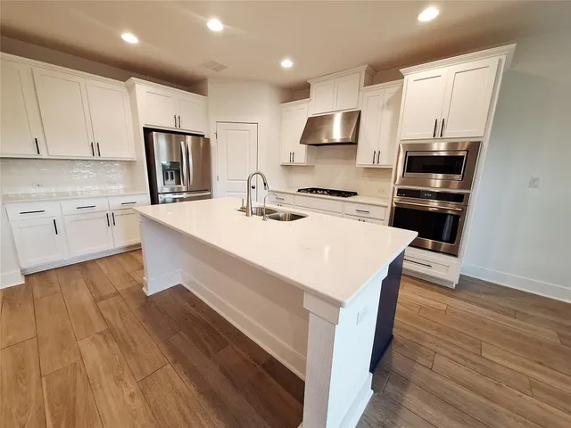 a kitchen with a sink a microwave a stove and refrigerator
