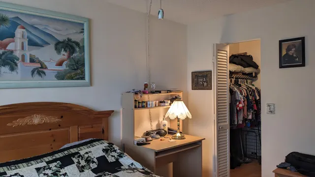a bedroom with bed and a painting on the wall