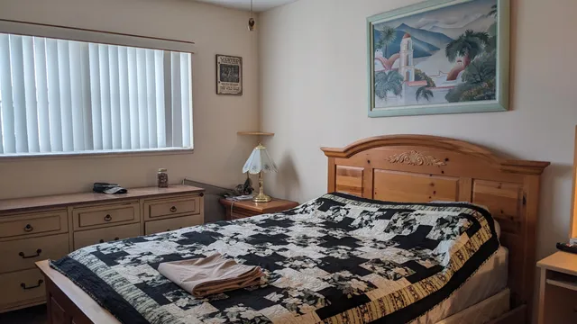 a bed sitting in a bedroom next to a window