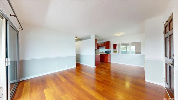a view of empty room with wooden floor